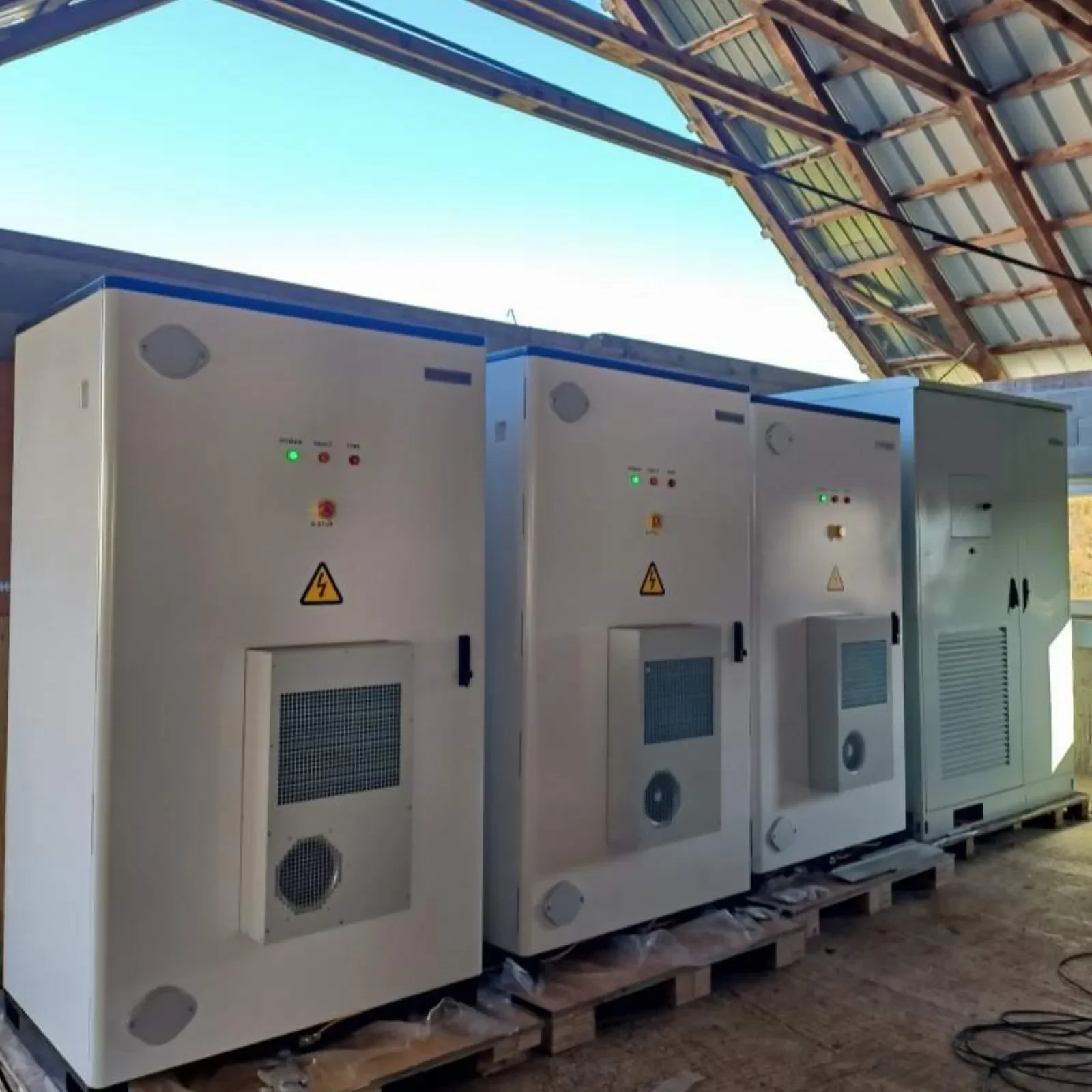 Row of commercial battery storage cabinets on a retrofit site, the commercial-scale answer to the interface question