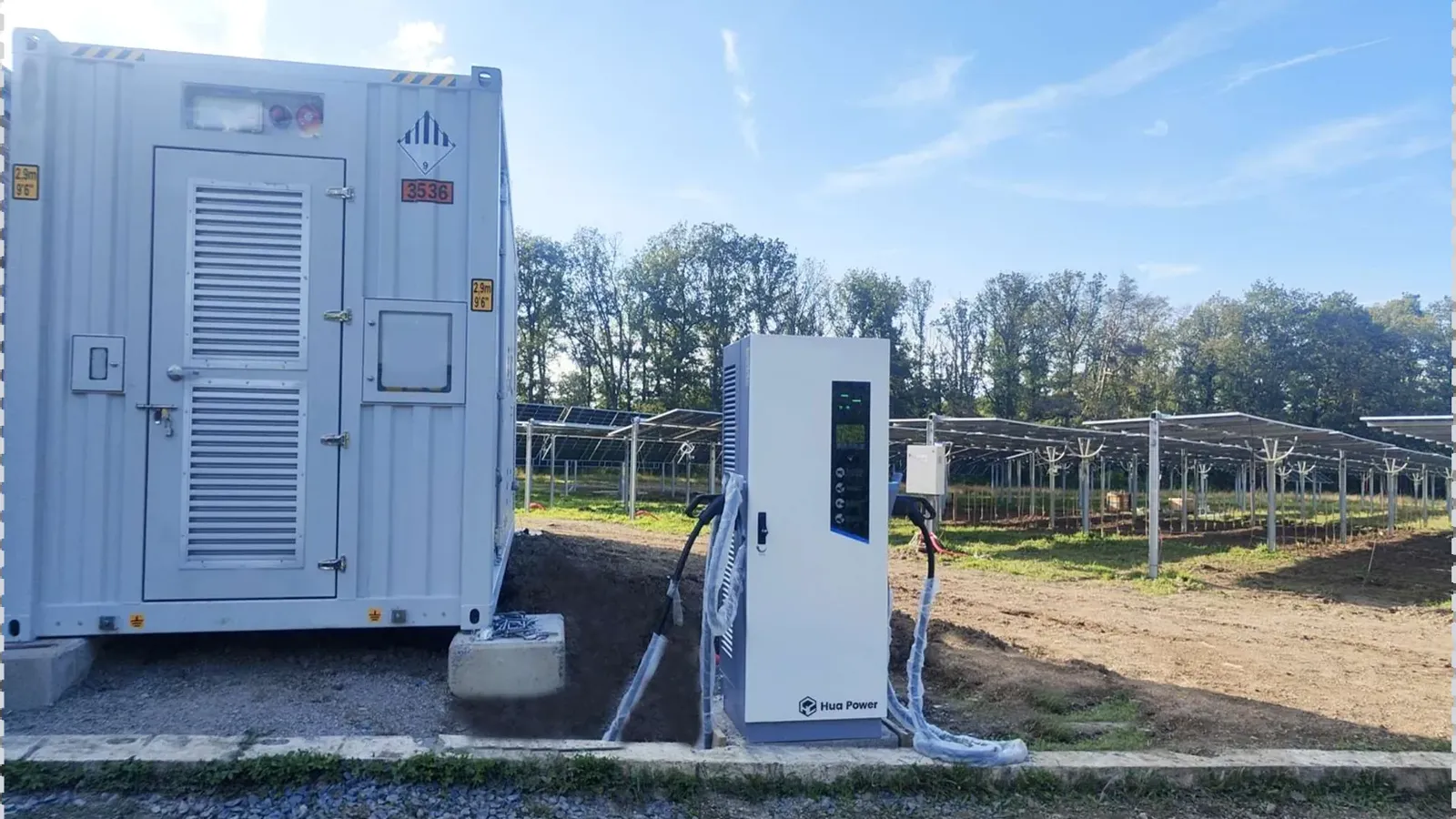 A containerised battery storage unit delivered and set on its pad beside an existing solar array before commissioning