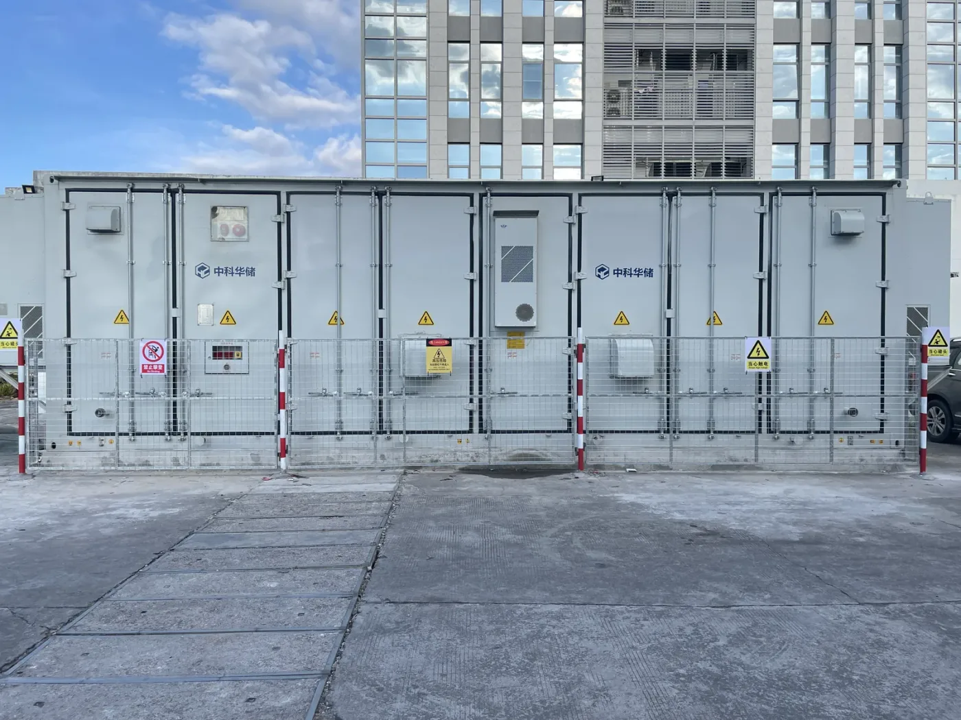 Hua Power liquid-cooled battery containers installed and commissioned on site, with protective fencing and safety signage