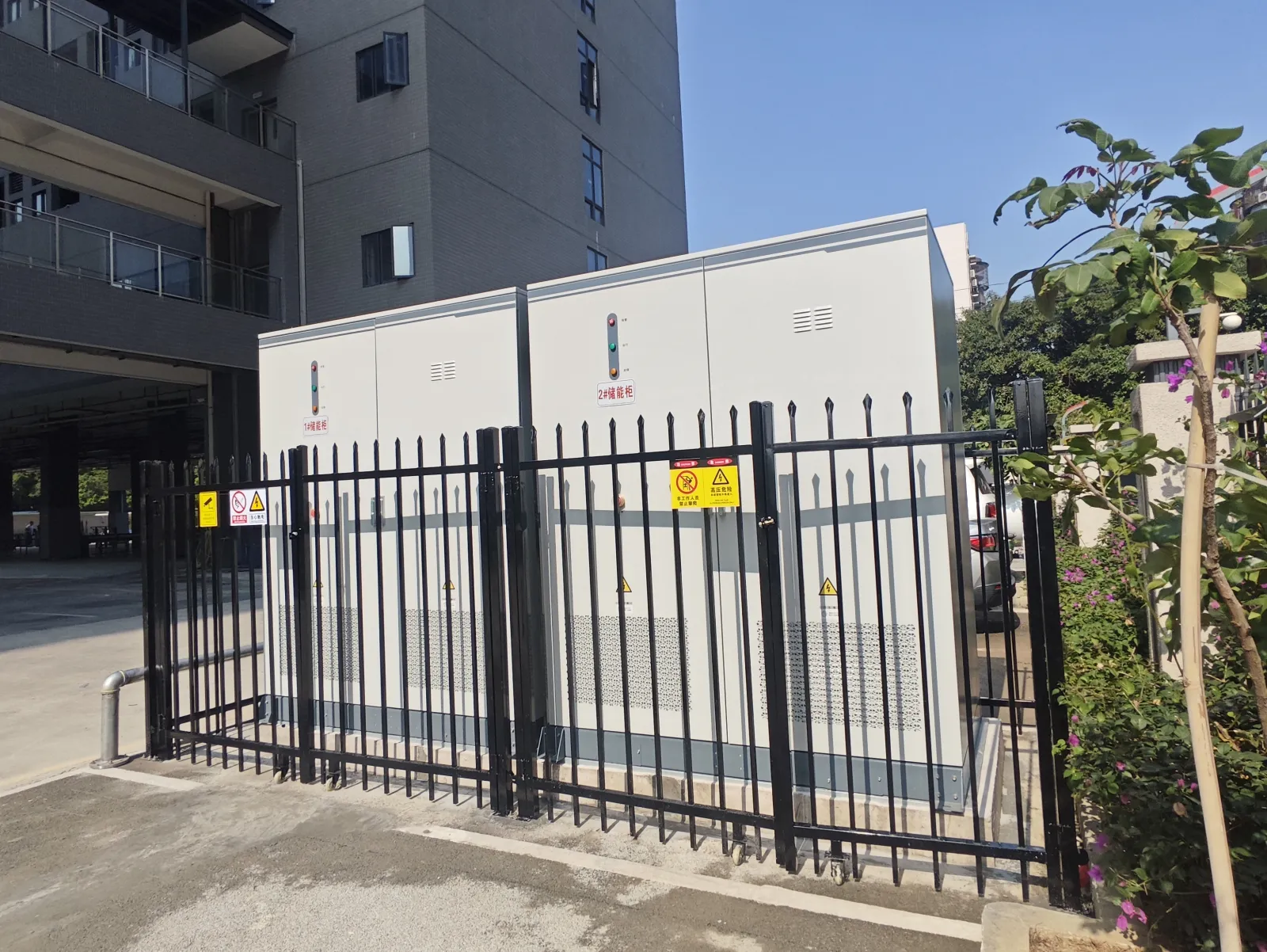 Hua Power outdoor IP54 commercial energy storage cabinets installed on a pad behind site fencing